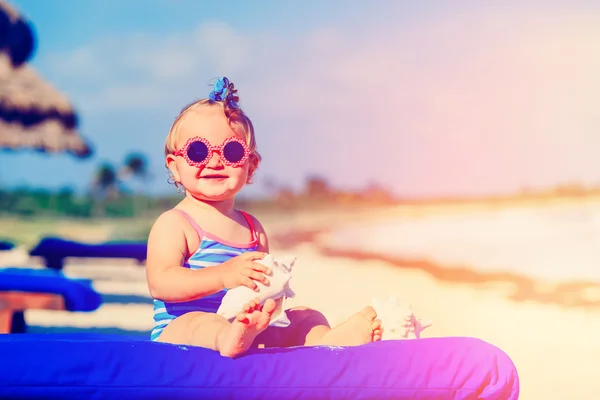 Bonito pequena menina com conchas na praia tropical — Fotografia de Stock