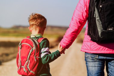 Aile seyahat - anne yolda oğlunun elini tutarak