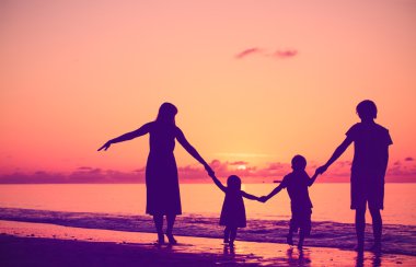 gün batımında yürüyen iki çocuklu mutlu aile