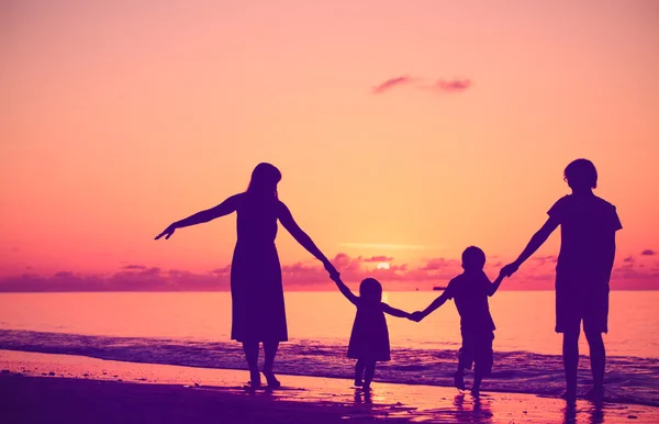 Famiglia felice con due bambini che camminano al tramonto — Foto Stock