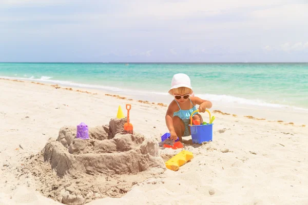 Schattig klein meisje spelen met zand op het strand — Stockfoto