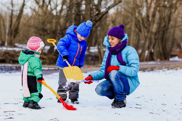 Moeder met twee kinderen spelen in de winter — Stockfoto