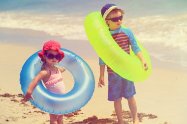 küçük erkek ve kız plajda yüzmek git