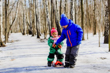 küçük kardeşim scooter binmek için ablasına yardım etmeye