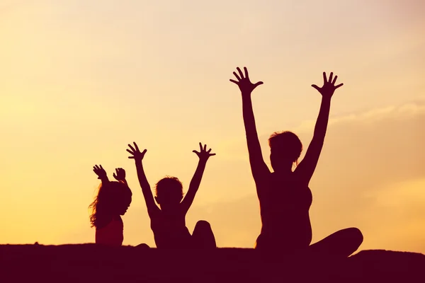 Silhouette of happy mother and kids at sunset — Stock Photo, Image
