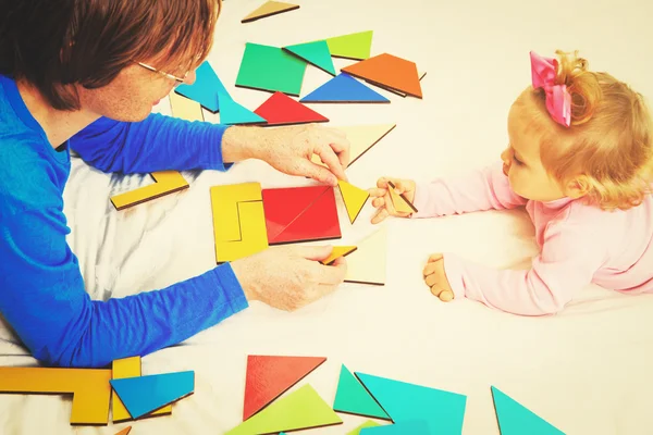 Enseignant et enfant jouant avec des formes géométriques, apprentissage précoce — Photo