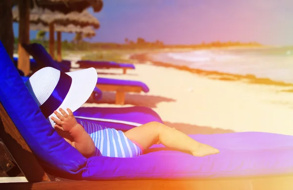 Klein meisje in grote hoed ontspannen op tropisch strand — Stockfoto