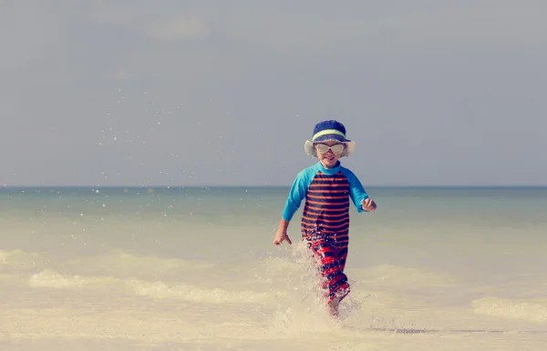 Szczęśliwy chłopiec działa na piaszczystej plaży — Zdjęcie stockowe