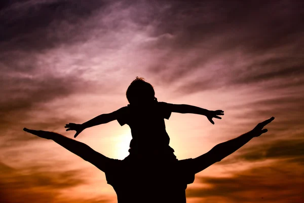 Padre e figlio giocano sul cielo del tramonto — Foto Stock