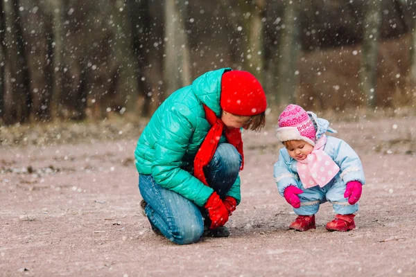 Mother and little daughter playing outdoors in winter — Stock Photo, Image