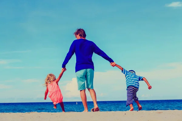 Vader en zoon en dochter spelen op strand — Stockfoto