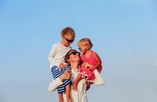 Gelukkig vader met twee kinderen op schouders naar hemel — Stockfoto