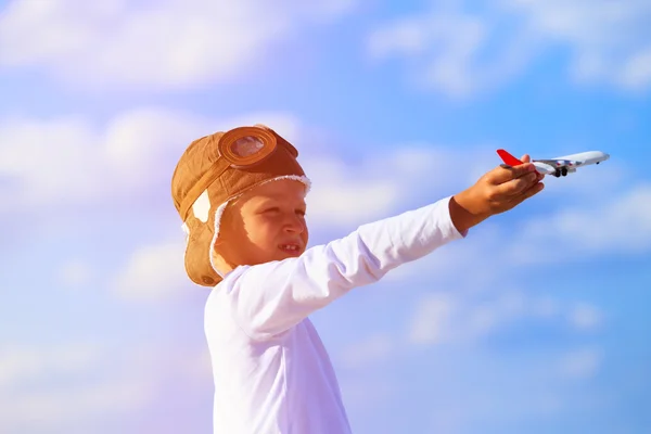 Ragazzo felice che gioca con aeroplano giocattolo su cielo blu — Foto Stock