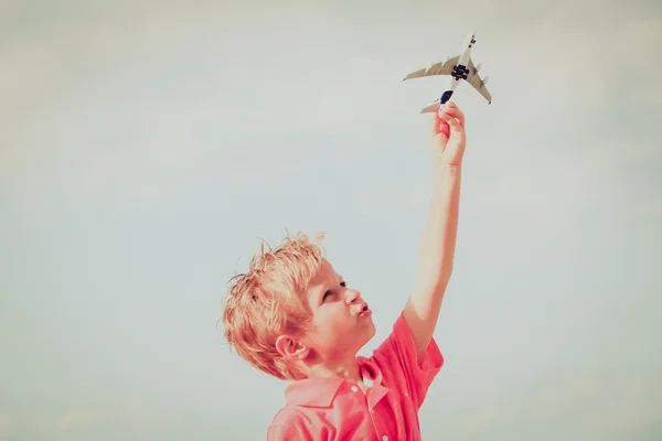 Criança feliz brincando com avião de brinquedo no céu azul — Fotografia de Stock