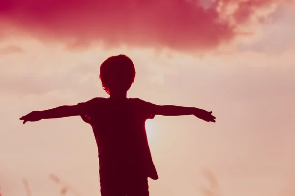 Silhouette of little boy play at sunset sky — Stockfoto