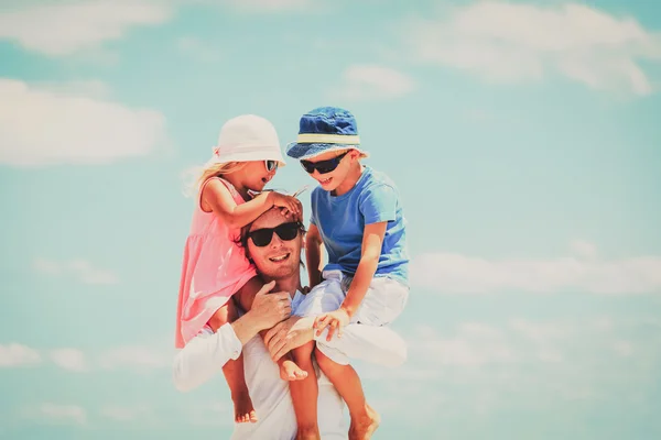 Appy father with two kids on shoulders at sky — Stock fotografie