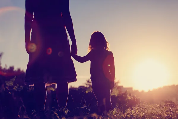 Moeder en dochtertje wandelen in de natuur van de zonsondergang — Stockfoto