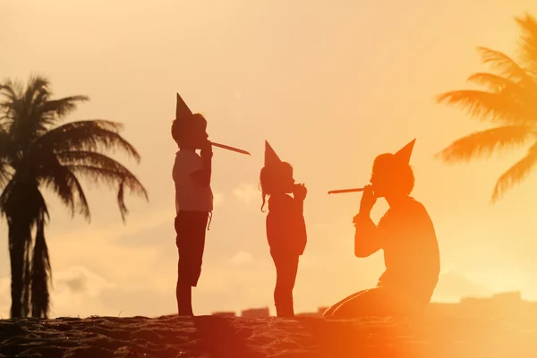 Пляжна сімейна вечірка батько і діти грають на заході сонця — стокове фото