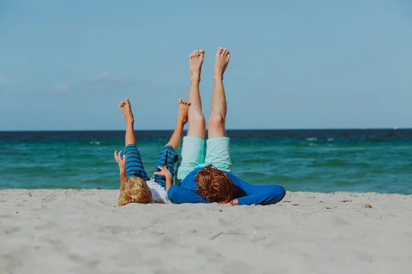Vader en zoontje spelen op strand — Stockfoto