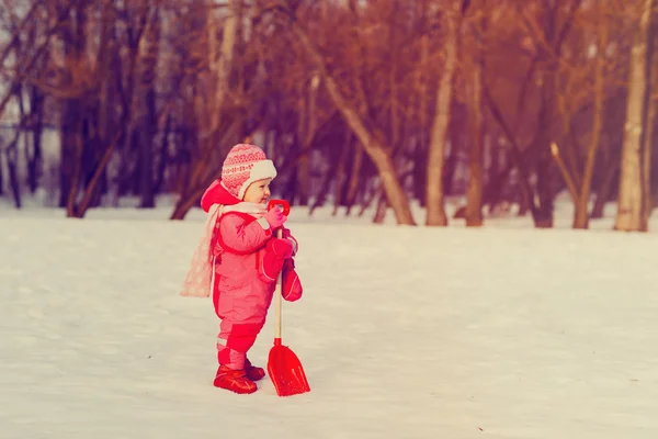 Sevimli küçük yürümeye başlayan çocuk kız kış karda kazmak — Stok fotoğraf