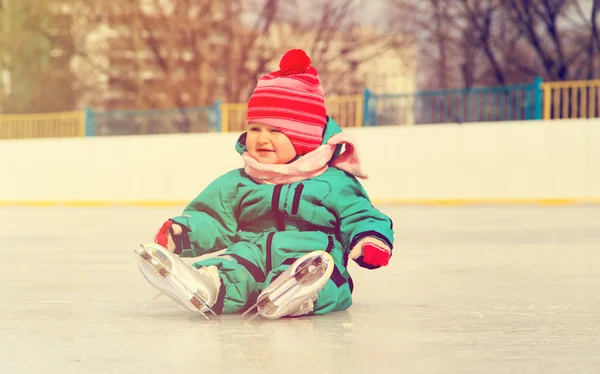 Χαριτωμένο μικρό κορίτσι που κάθεται στον πάγο με πατίνια μετά την πτώση — Φωτογραφία Αρχείου