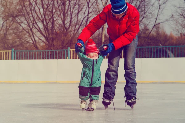 Отец и маленькая дочь учатся кататься на коньках — стоковое фото