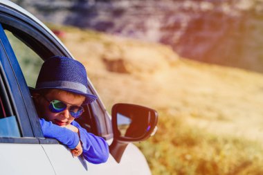 mutlu küçük çocuk doğada araba ile seyahat