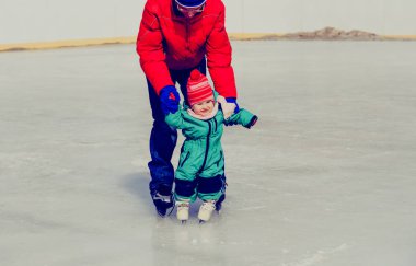 Baba ve küçük kızı kışın paten için öğrenme