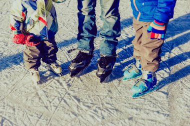 babası iki çocukla kışın buz pateni