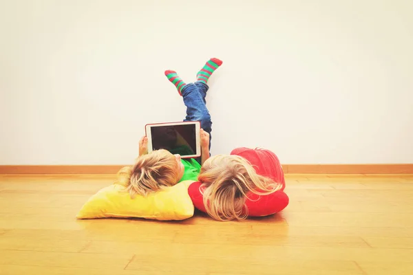 Kleine Jungen und Mädchen schauen auf Touchpad, lernen zu Hause — Stockfoto