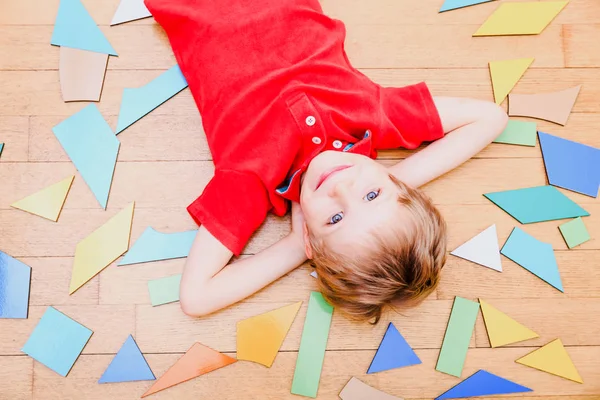 Kids learning - little boy with puzzle toys on wooden floor — Stock Photo, Image