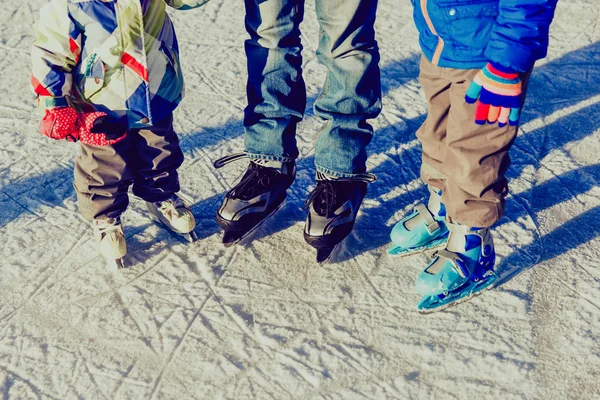 babası iki çocukla kışın buz pateni