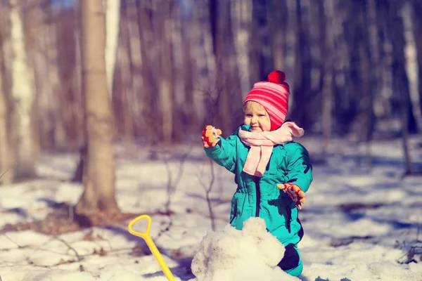 Little girl digging snow in winter, kids activities — Stock Photo, Image