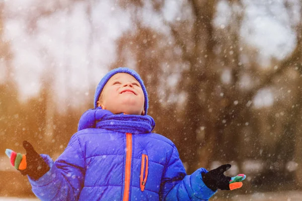 Mały chłopiec cieszyć się pierwszy śnieg w zimie przyrodzie — Zdjęcie stockowe