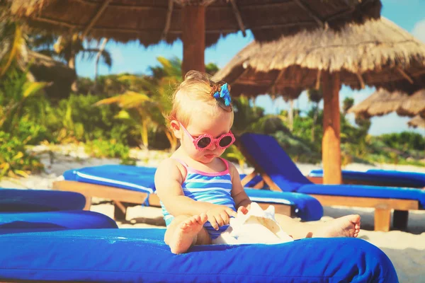 Roztomilá holčička hrát s mušle na pláži — Stock fotografie