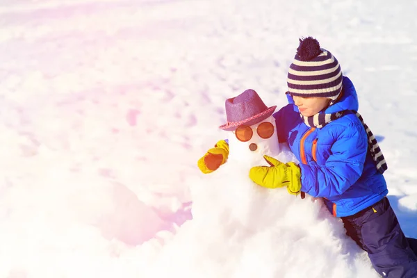 Μικρό αγόρι με χιονάνθρωπος χειμώνα χαρακτήρα — Φωτογραφία Αρχείου