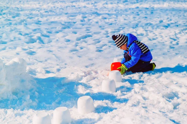 Menino construindo castelo de neve — Fotografia de Stock