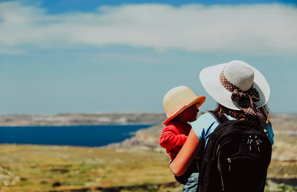Семейные путешествия - мать с маленькой дочерью, смотрящей на горы — стоковое фото