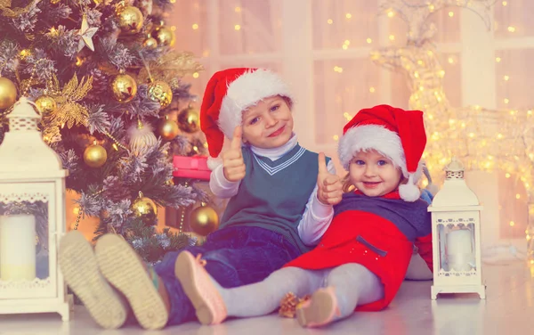 Ευτυχής παιδιά περιμένουν για τα Χριστούγεννα παρουσιάζει σε διακοσμημένο σαλόνι — Φωτογραφία Αρχείου