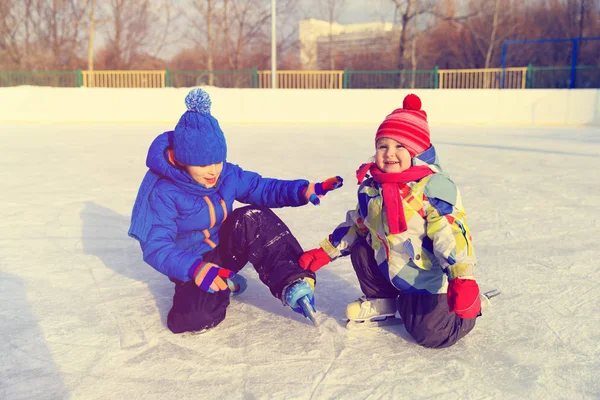 Kis fiú és lány együtt, korcsolyázni a gyerekek téli sport — Stock Fotó