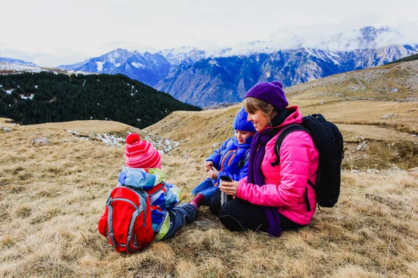 Mor och två barn resa i vintern berg — Stockfoto