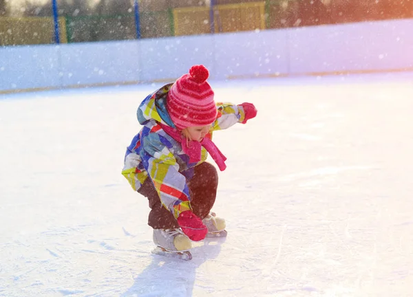 Милая маленькая девочка учиться кататься на коньках зимой — стоковое фото