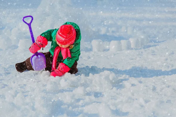 Little girl dig and play in winter snow — Stock Photo, Image