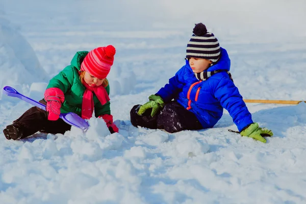 küçük erkek ve kız kış aylarında kar kazı