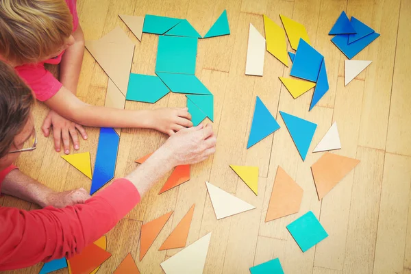 Руки учителя и ребенка, играющие с геометрическими фигурами — стоковое фото