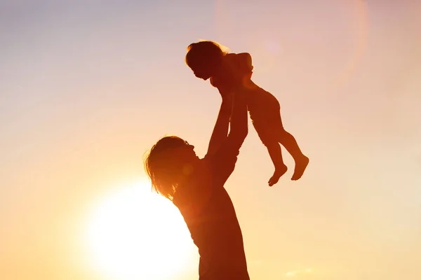 Silhouettes père et petite fille au coucher du soleil — Photo