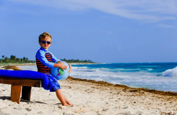 Rodzina travel - mały chłopiec z globe na tropikalnej plaży — Zdjęcie stockowe