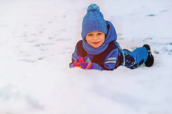 Щасливий маленький хлопчик розважається в зимовому снігу — стокове фото