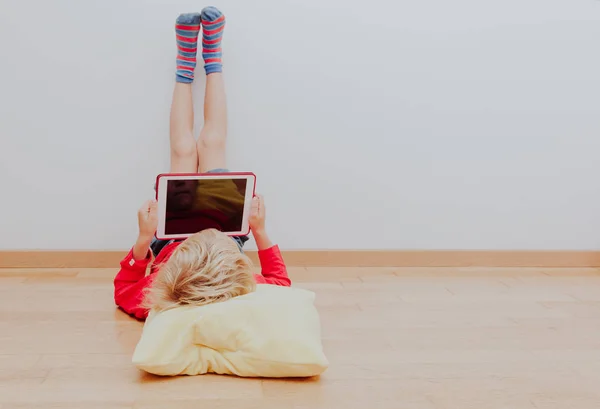 Kleiner Junge schaut zu Hause auf Touchpad — Stockfoto