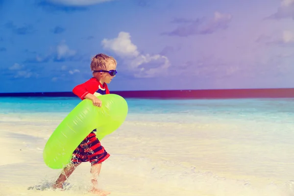 Mały chłopiec popływać w szerzy się pierścienia na plaży — Zdjęcie stockowe